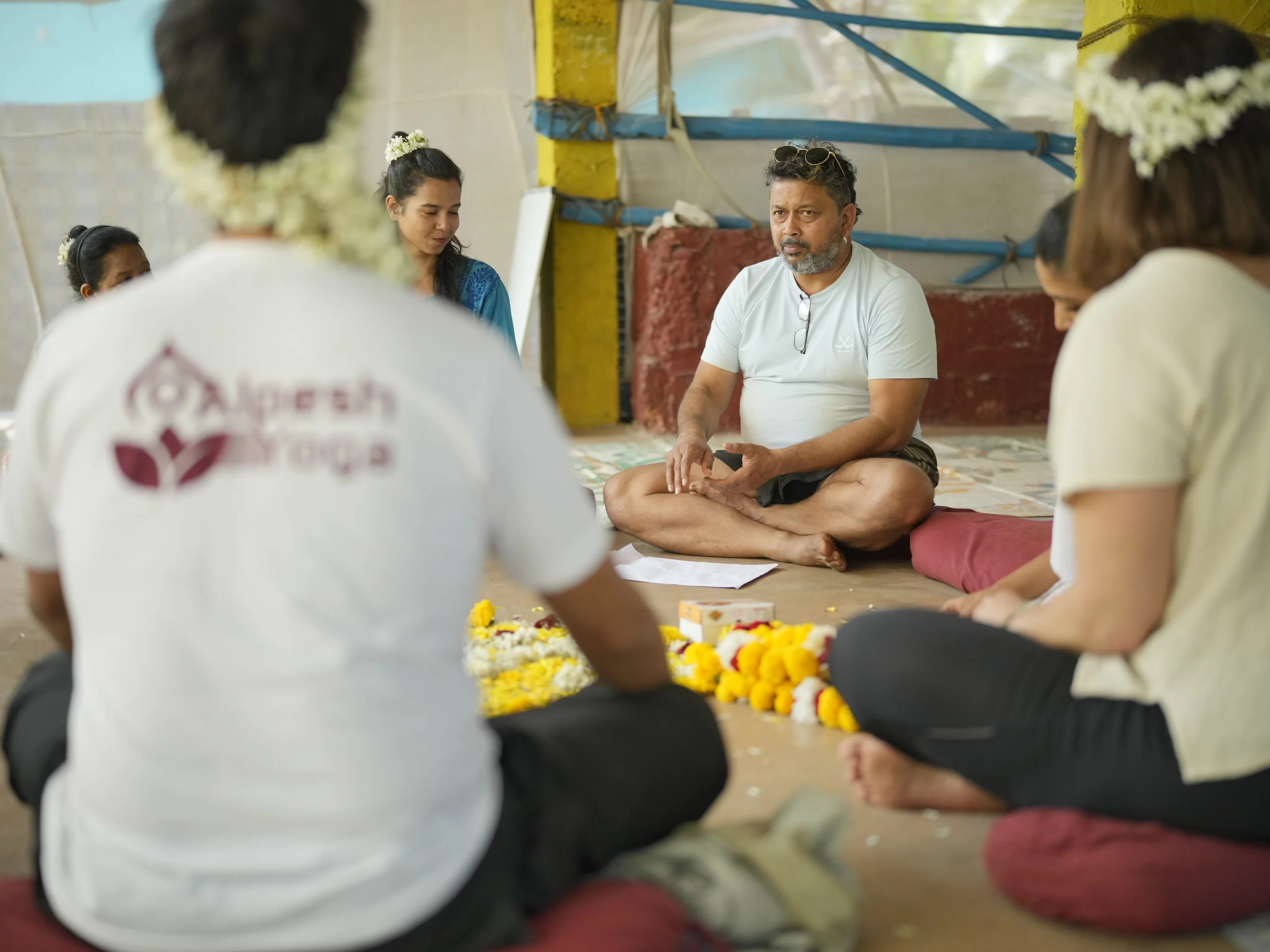Alpesh Patwari teaching a circle of yoga teacher training students inside the Alpesh Yoga shala