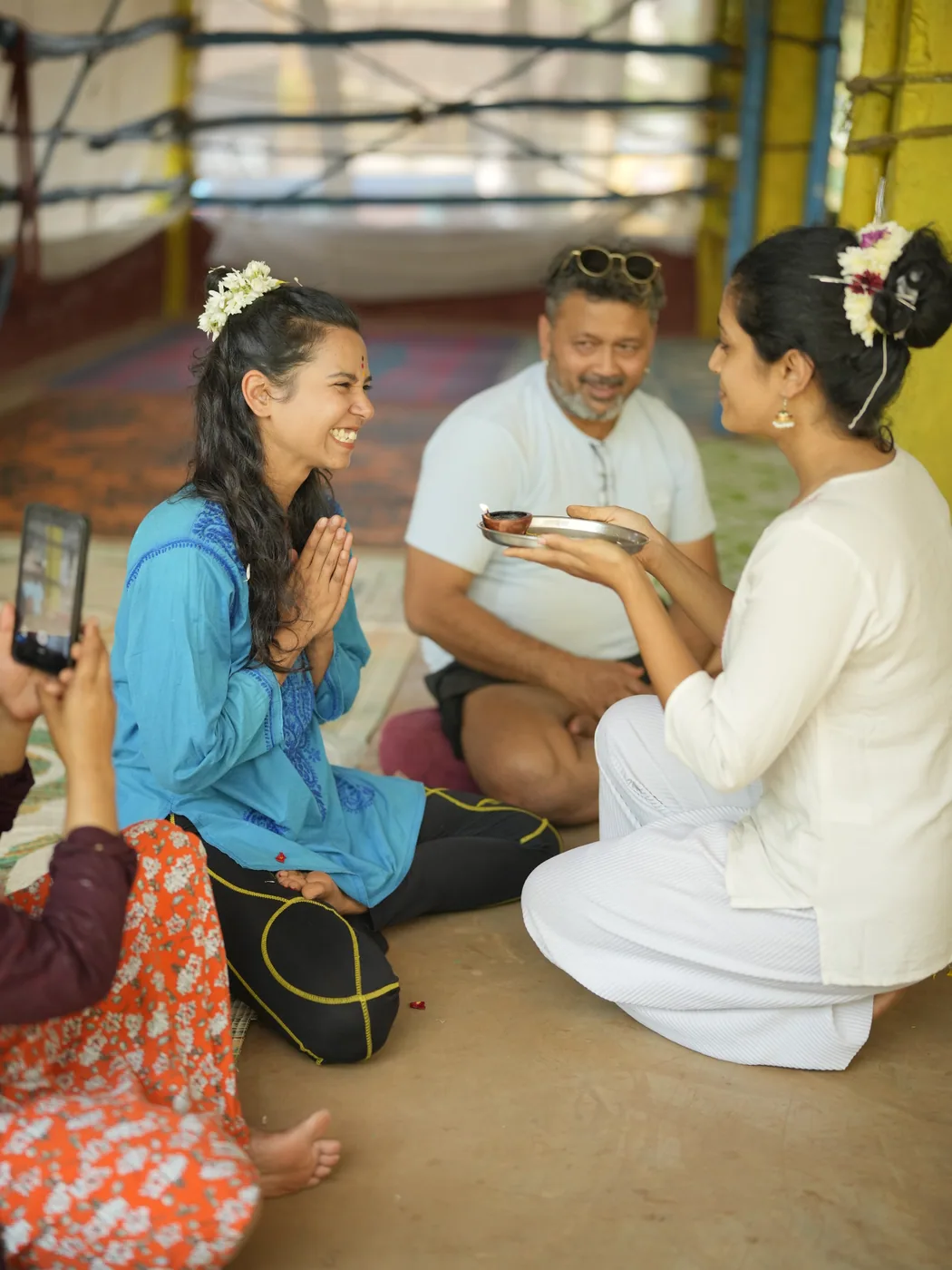 Yoga student in namaste receiving a blessing during the opening ceremony of her teacher training course