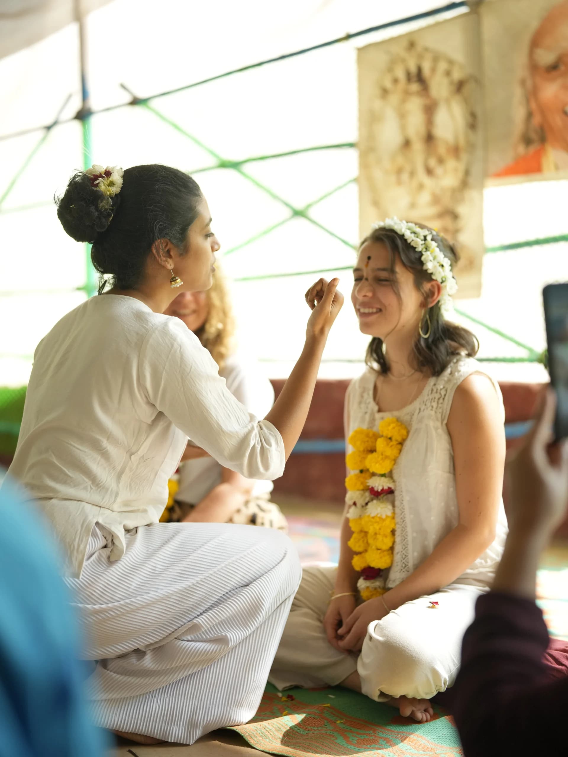 Student receiving a tilak blessing with flower garlands at the Alpesh Yoga opening ceremony