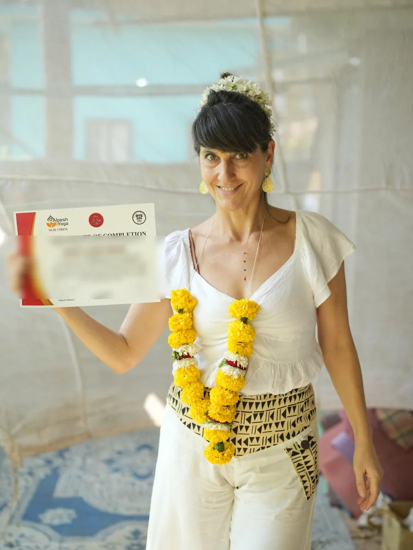 Alpesh Yoga graduate presenting her Yoga Alliance 200-hour certificate of completion after the closing ceremony