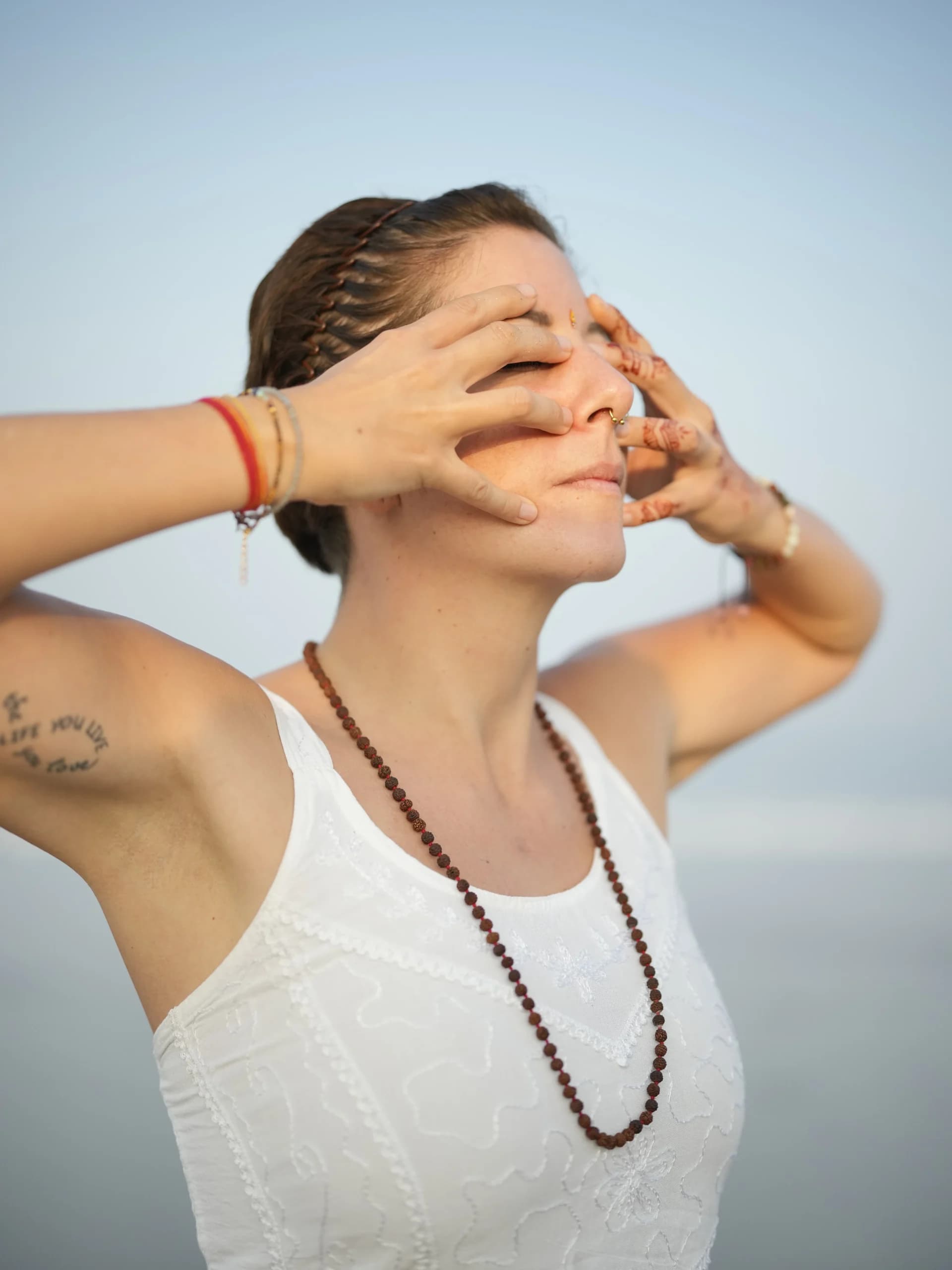 Student practicing a pranayama breathing technique outdoors at Alpesh Yoga, Goa