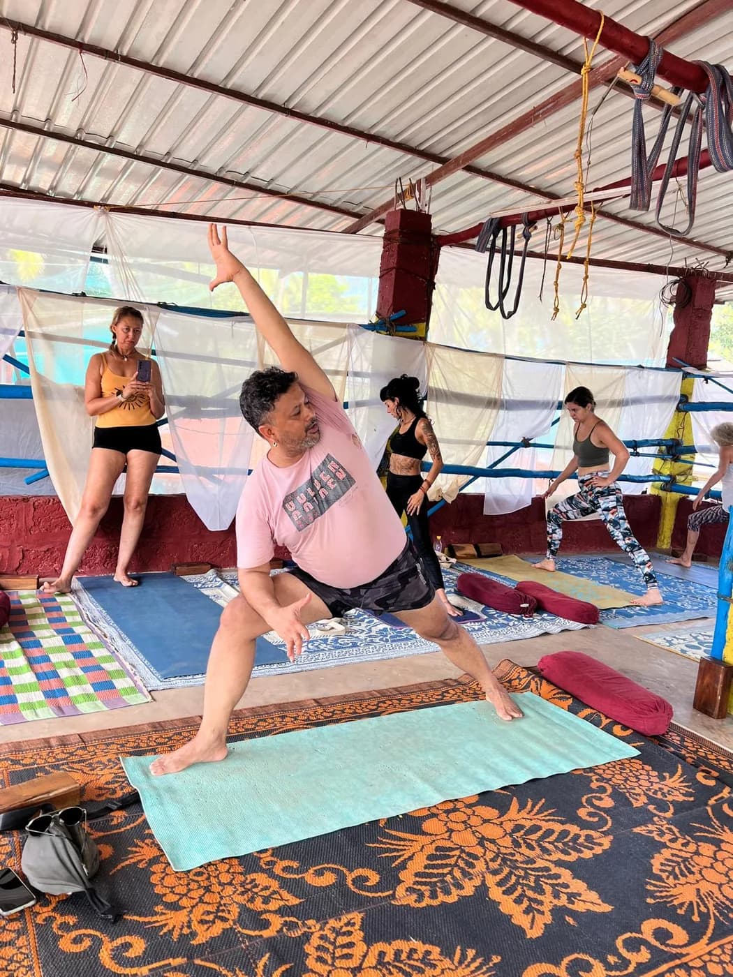 Students holding extended side angle pose during a morning alignment class at the Arambol shala