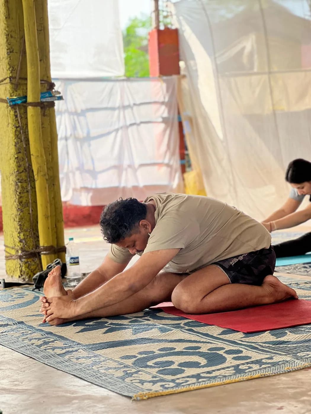Student in a seated forward bend during morning practice at the Arambol yoga shala